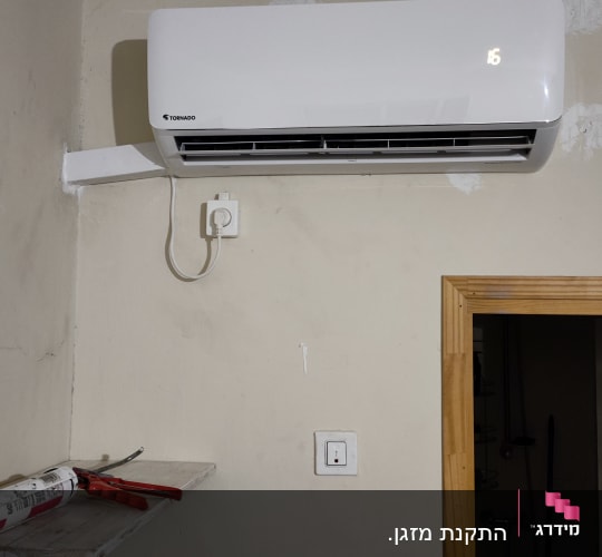 מזגן מותקן על קיר עם תצוגת טמפרטורה דולקת